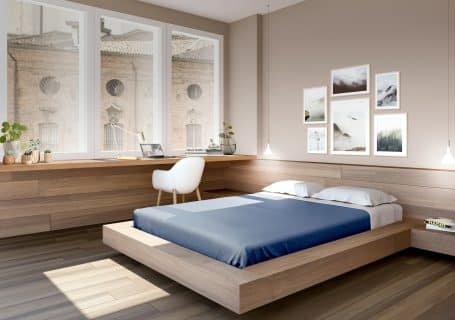 a bed room with a neatly made bed and a desk
